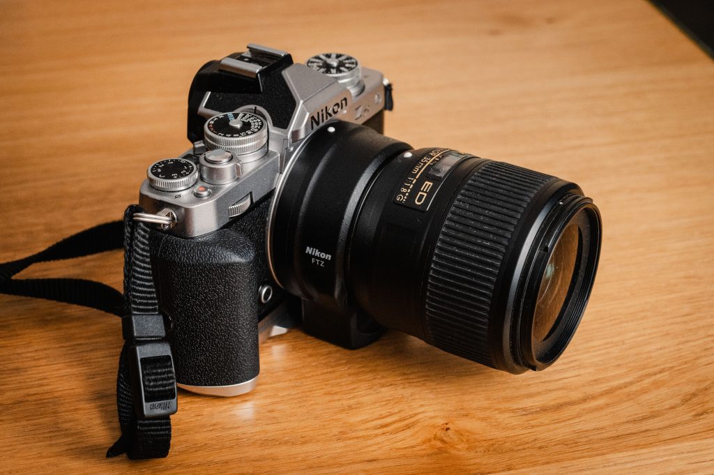 Nikon Zfc mit Nikon FTZ Adapter. Daran montiert ist ein Nikon AF-S Nikkor 35mm f/1.8 G ED.